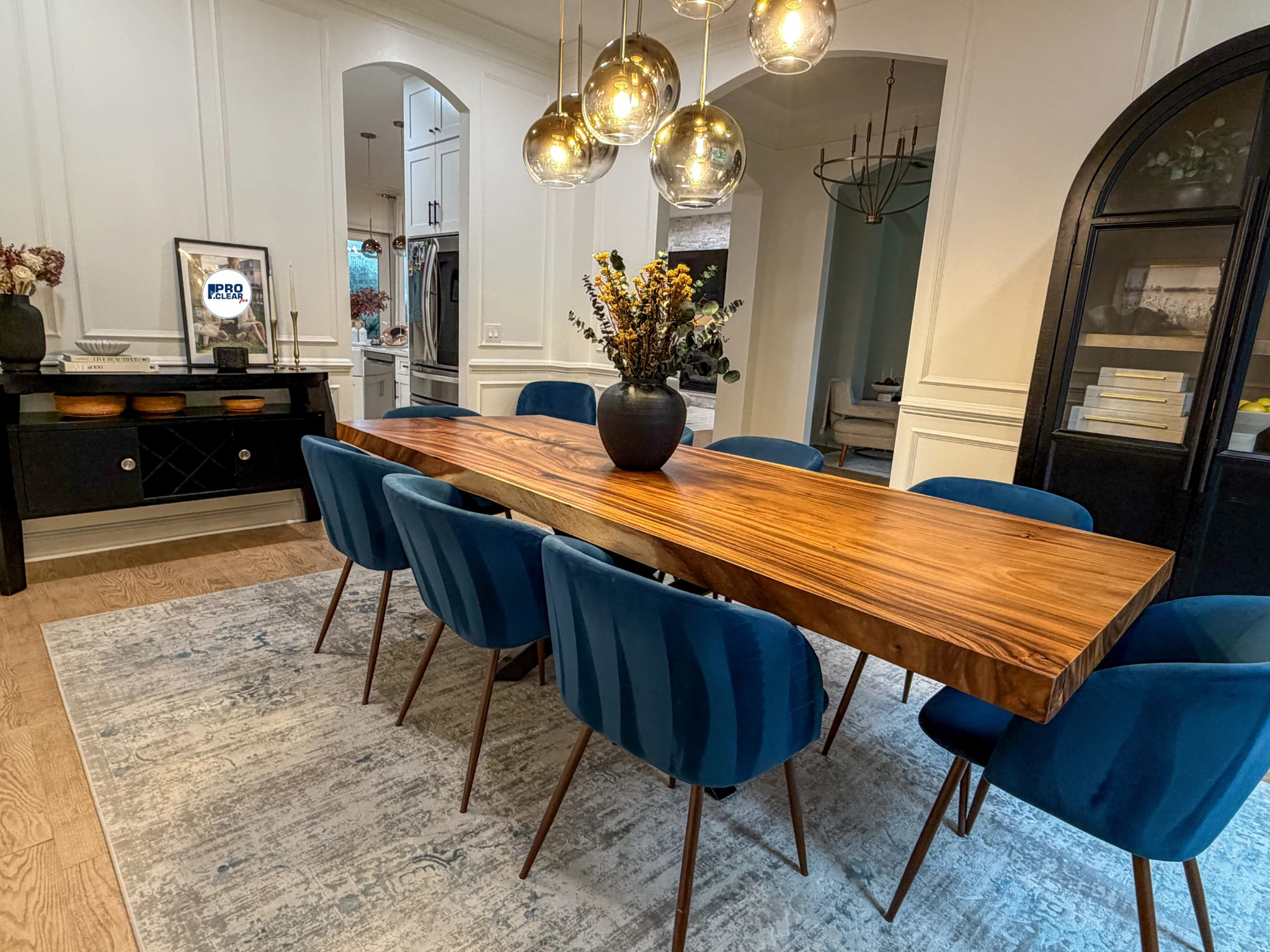 Dining room with a wood table, blue chairs, and glass pendant lights